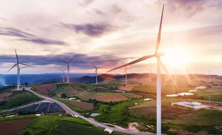 Wind turbines in countryside at sunset