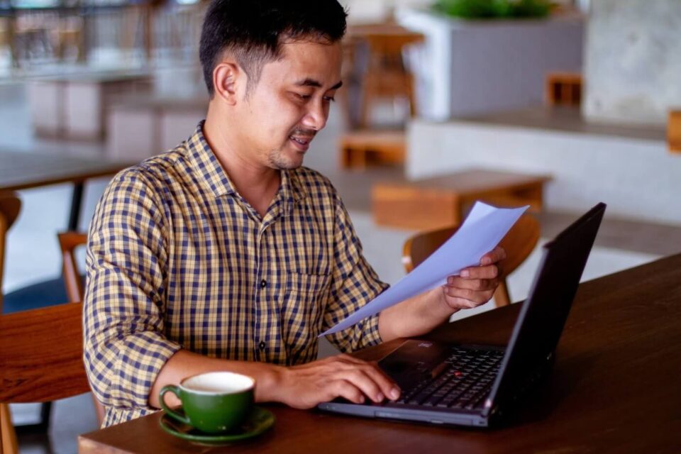 Individual working on his laptop in a cafe shop