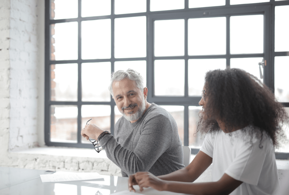 A mentor meets with a new employee at desk